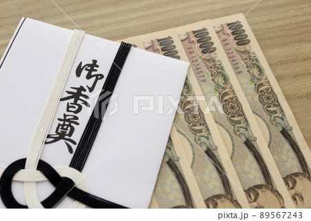白木机に置かれたご仏前の封筒と一万円札 89567243
