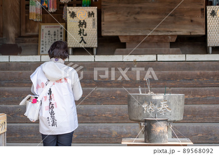 四国霊山寺でお遍路用の服でお参りをしている女性 89568092