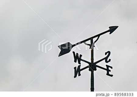曇天の下で方角を示す風見鶏を見上げる　東西南北 89568333