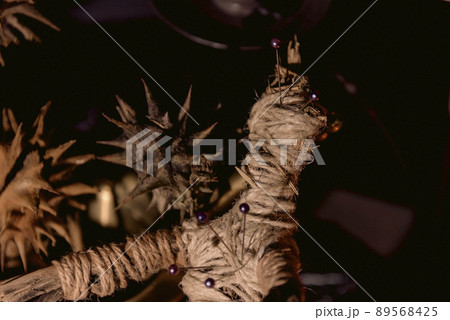 Voodoo Magic concept. Voodoo doll studded with needles with pierced rag heart on pentagram and around burning candles. Spooky or eerie magical esoteric ritua. Voodoo Magic concept. Voodoo doll studded with needles with pierced rag heart on pentagram and around burning candles. Spooky or eerie magical esoteric ritua. 89568425