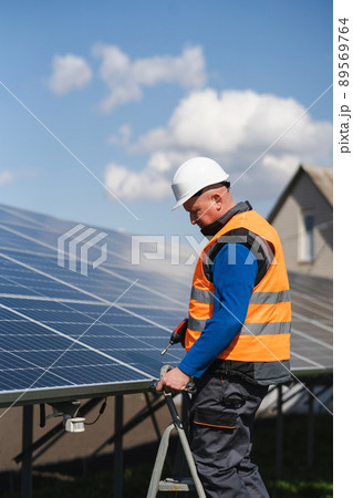 Solar panel assembler stands on a ladder Solar panel assembler stands on a ladder 89569764