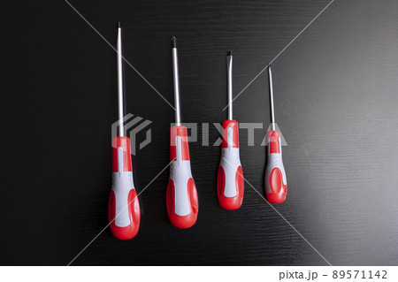 Four screwdrivers of different sizes on wooden background Four screwdrivers of different sizes on wooden background 89571142
