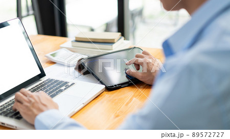 Business analyst concept the businessman using both computer laptop and tablet to monitor the sale of stock 89572727