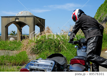 海岸近くの駐車場でサイドカーの点検と試運転を行うドライバー 89576301
