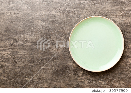 Top view of empty green plate on cement background. Empty space for your design 89577900