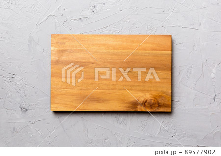Top view of wooden cutting board on cement background. Empty space for your design Top view of wooden cutting board on cement background. Empty space for your design 89577902