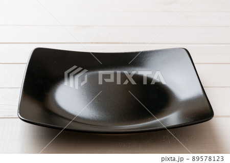 Perspective view of empty square plate on wooden background. Empty space for your design Perspective view of empty square plate on wooden background. Empty space for your design 89578123