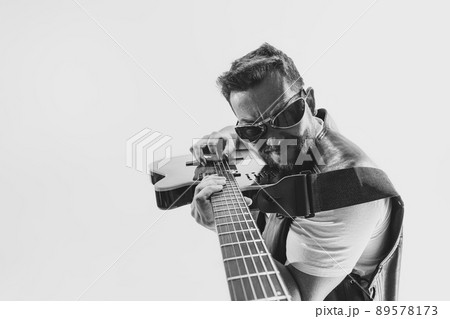 Solo performance Black and white portrait of stylish rock musician with electric guitar isolated on white background. Concept of art, music, style 89578173