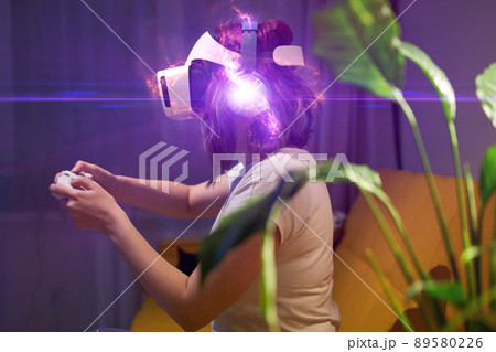 Woman with virtual reality headset and joystic is playing game. Elements image furnished by NASA. 89580226