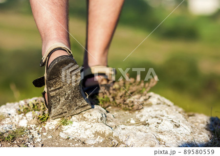 Successful hiker legs walking on mountain peak rock. Adventure and exercising in summer nature. 89580559