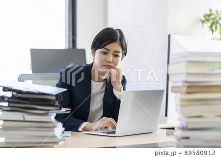デスクワーク ノートパソコンの画面を見ながら考え込む若いビジネスウーマン デスクワーク ノートパソコンの画面を見ながら考え込む若いビジネスウーマン 89580912