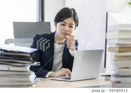 デスクワーク ノートパソコンの画面を見ながら考え込む若いビジネスウーマン デスクワーク ノートパソコンの画面を見ながら考え込む若いビジネスウーマン 89580913