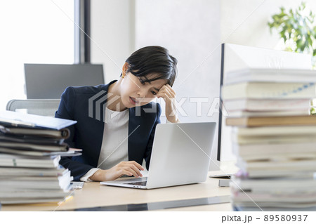 デスクワーク ノートパソコンの画面を見ながら頭を抱えるビジネスウーマン デスクワーク ノートパソコンの画面を見ながら頭を抱えるビジネスウーマン 89580937