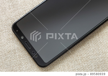 New black modern cellphone isolated on light cloth copy space background. Modern technology, communication and gadget design concept. 89580939