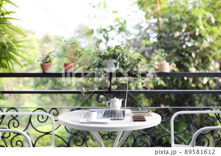 White Coffee cup and laptop and with plants pot on white metal table at balcony 89581612