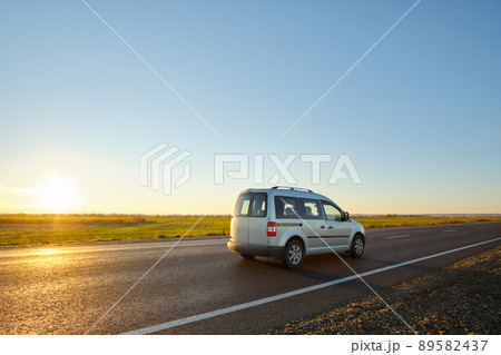 Car driving fast on intercity road at sunset. Highway traffic in evening 89582437
