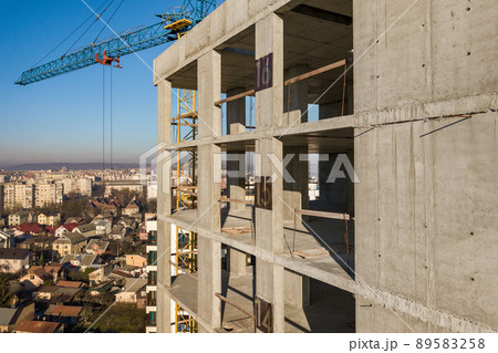 Aerial view of concrete frame of tall apartment building under construction in a city. 89583258
