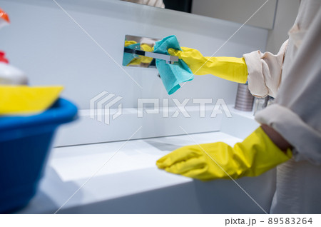 A young housewife cleaning in the bathroom 89583264