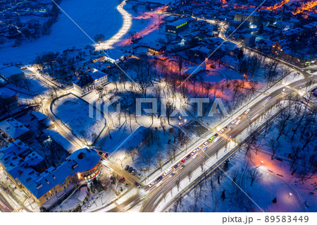 Beautiful evening top view of the city. Evening, night illumination in the city. Winter city in the snow. 89583449
