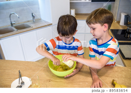 happy family funny kids are preparing the dough, bake cookies in the kitchen 89583654