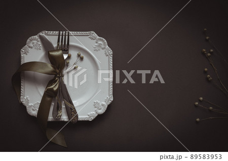 Romantic tabble setting with ribbon, plates, cutlery on black background. Empty plate. Mockup design layout for your text. Love romantic concept. Copy space. Top view. Flat lay. 89583953