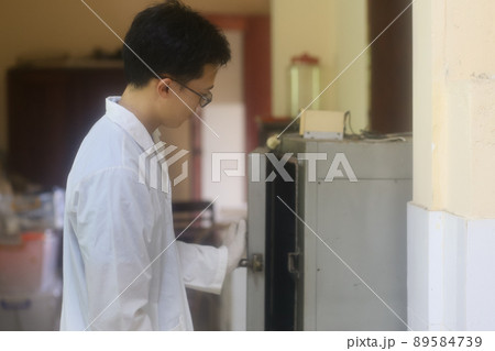 Asian man scientist checking drying and heating oven in the laboratory Asian man scientist checking drying and heating oven in the laboratory 89584739