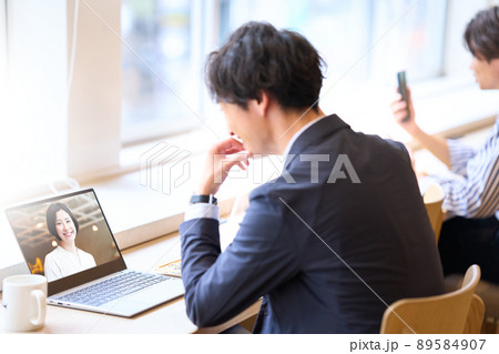 ノートPCを開いてビデオ会議をしている男性 89584907