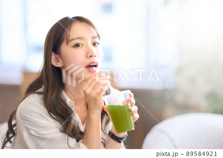 ストローを使って野菜ジュースを飲む若い女性 ストローを使って野菜ジュースを飲む若い女性 89584921
