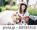 Asian woman playing guitar in the park, lifestyle and recreation concept. Asian woman playing guitar in the park, lifestyle and recreation concept. 89585916