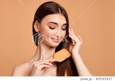 Beautiful woman combs her hair with wooden brush Beautiful woman combs her hair with wooden brush 89585937
