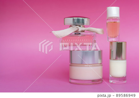 Pink glass perfume bottle, facial cream and nail care product on pink background. Bottle of female perfume, skin care, cosmetic, free space for text. Pink glass perfume bottle, facial cream and nail care product on pink background. Bottle of female perfume, skin care, cosmetic, free space for text. 89586949