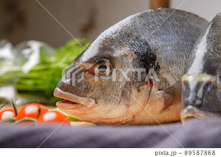 Fresh dorado fish, on a wooden board, two heads close-up 89587868