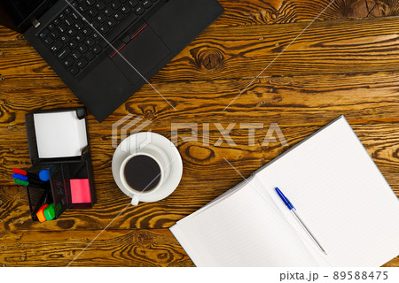Laptop with cup of coffee on old brown wooden table. Top view to Notebook with cup of fresh coffee in home office in village. Laptop with cup of coffee on old brown wooden table. Top view to Notebook with cup of fresh coffee in home office in village. 89588475