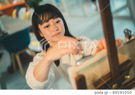 目玉クリップでB3パネルに画用紙を止めてデッサンをする女子 89591050