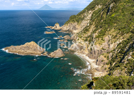 佐多岬から見下ろす大隅半島の絶壁と、鹿児島湾の向こうに見える薩摩半島にそびえ立つ開聞岳 89591481
