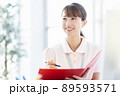 施設内でファイルと筆記用具を持つ医療従事者の女性 89593571