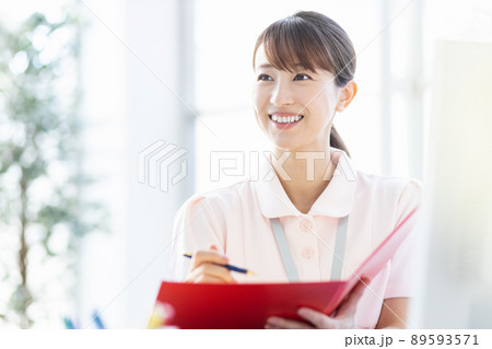 施設内でファイルと筆記用具を持つ医療従事者の女性 施設内でファイルと筆記用具を持つ医療従事者の女性 89593571