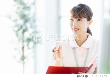 施設内でファイルと筆記用具を持つ医療従事者の女性 89593576