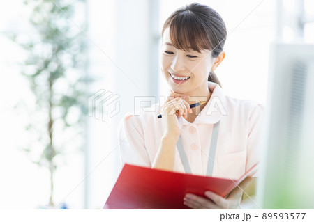 施設内でファイルと筆記用具を持つ医療従事者の女性 89593577