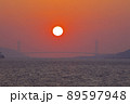 明石海峡大橋の真ん中に沈み行く夕陽（神戸ポートアイランド 西岸緑地公園より） 89597948