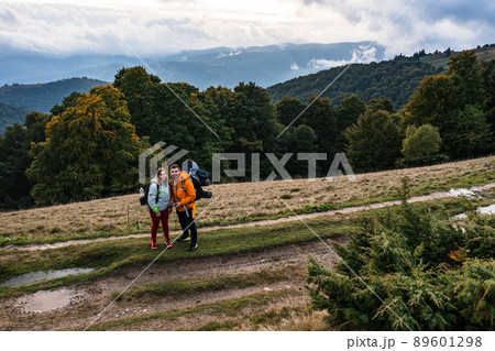 Tourists walk through the Ukrainian Carpathians, tourists carry heavy backpacks on their backs. Tourists walk through the Ukrainian Carpathians, tourists carry heavy backpacks on their backs. 89601298