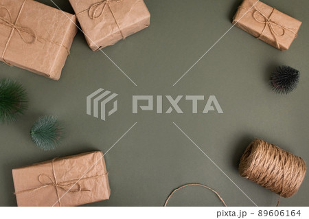 Celebratory Christmas and New Year's holidays background. Gift boxes wrapped craft paper with twine , recycling present on green background  89606164