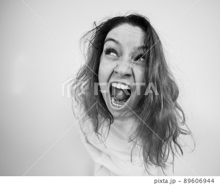 Close-up portrait of insane woman in straitjacket on white background. Monochrome. 89606944