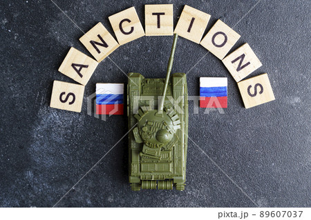 Sanctions against Russia concept. Toy tank and the inscription Sanctions on a dark background. War conflict in Ukraine, default, economic and monetary crisis in Russia. 89607037