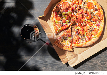 A box of pizza and a glass of wine on a summer day. Pizza delivery concept. Top view. Flat lay. A box of pizza and a glass of wine on a summer day. Pizza delivery concept. Top view. Flat lay. 89608935