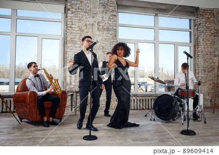 Young international musicians, a band performing on the loft stage. The concept of music, hobby, festival. Inspiration creativity. Young international musicians, a band performing on the loft stage. The concept of music, hobby, festival. Inspiration creativity. 89609414