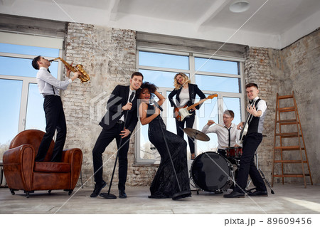 Young international musicians, a band performing on the loft stage. The concept of music, hobby, festival. Inspiration creativity. 89609456