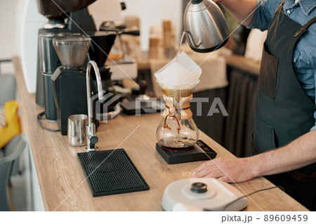 Close up of barista pouring water to make coffee using manual drip brewer Close up of barista pouring water to make coffee using manual drip brewer 89609459
