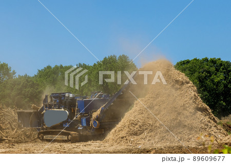 Construction site with work wood chipping machine the chipper process Construction site with work wood chipping machine the chipper process 89609677