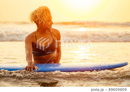 african american surfer girl in water enjoying sunset 89609809